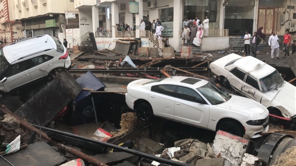 سيارات متراكمة على طريق جرفته السيول في حي العقيق. (تصوير: محمد الزيادي) 