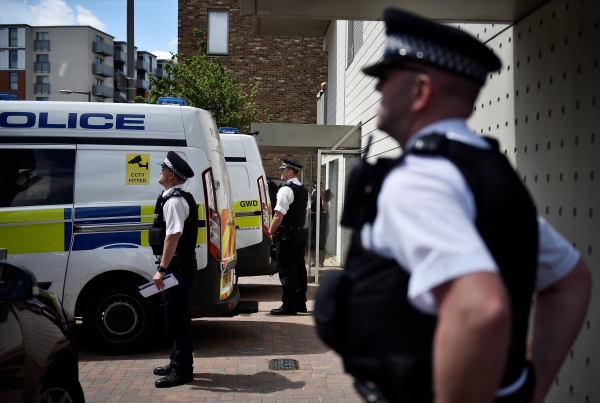 Officers and vehicles stand outside a block of flats that was raided by police in Barking, east London, Britain, June 4, 2017. REUTERS/Hannah McKay