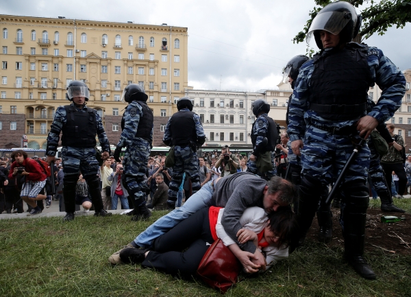 Activist Yulia Galyamina and her husband Nikolai Tuzhilin lie on the ground next to riot police during an anti-corruption protest organised by opposition leader Alexei Navalny, on Tverskaya Street in central Moscow, Russia June 12, 2017. REUTERS/Maxim Shemetov