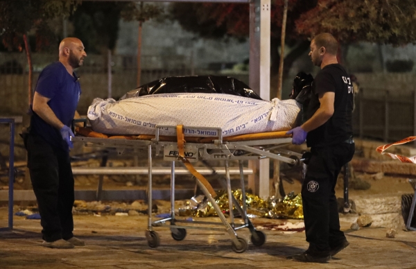 Israeli forensic police remove the bodies suspected Palestinian assailants outside Damascus Gate in Jerusalem's Old City on June 16, 2017 following an attack. An Israeli policewoman was stabbed and critically wounded in the attack, police said, with security forces shooting dead three suspected Palestinian assailants. / AFP / Ahmad GHARABLI
