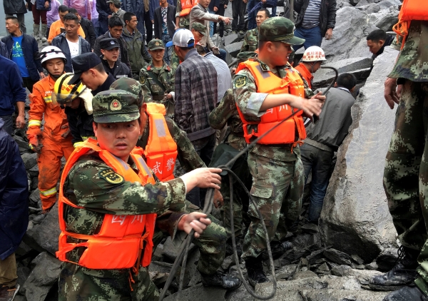 Rescue workers work at the site of a landslide that destroyed some 40 households, where more than 100 people are feared to be buried, according to local media reports, in Xinmo Village, China June 24, 2017. REUTERS/Stringer ATTENTION EDITORS - THIS IMAGE WAS PROVIDED BY A THIRD PARTY. CHINA OUT. NO COMMERCIAL OR EDITORIAL SALES IN CHINA.