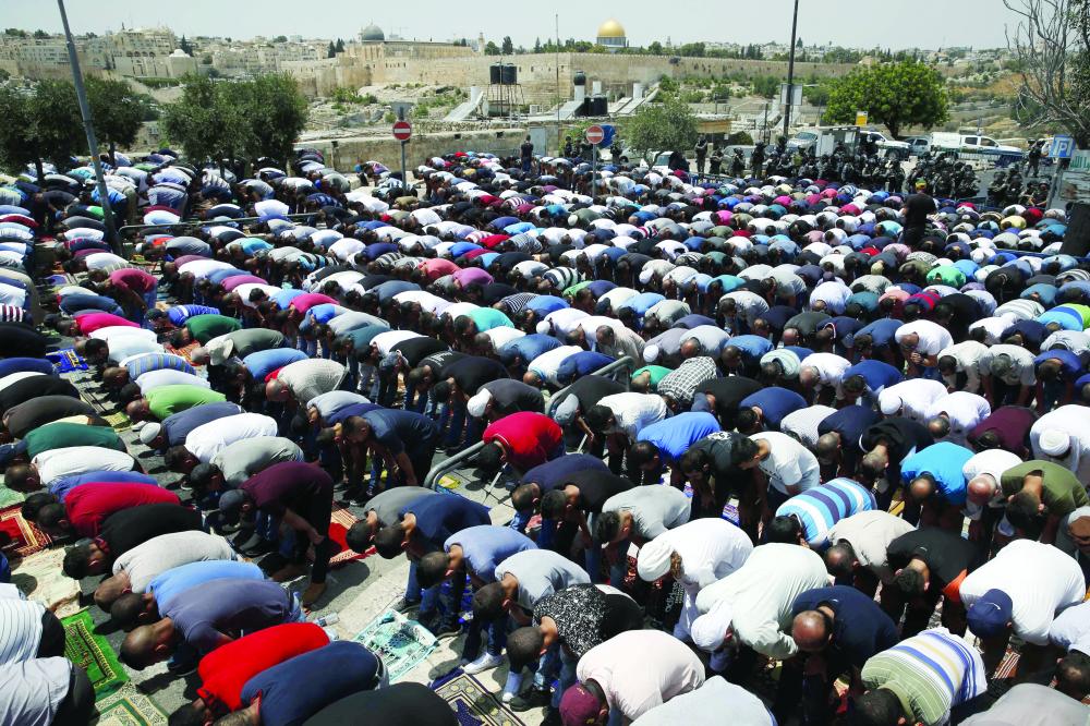 



فلسطينيون يصلون أمام باحة المسجد الأقصى بعد أن منعهم الاحتلال من الدخول إلى القدس القديمة أمس. (أ. ف. ب)