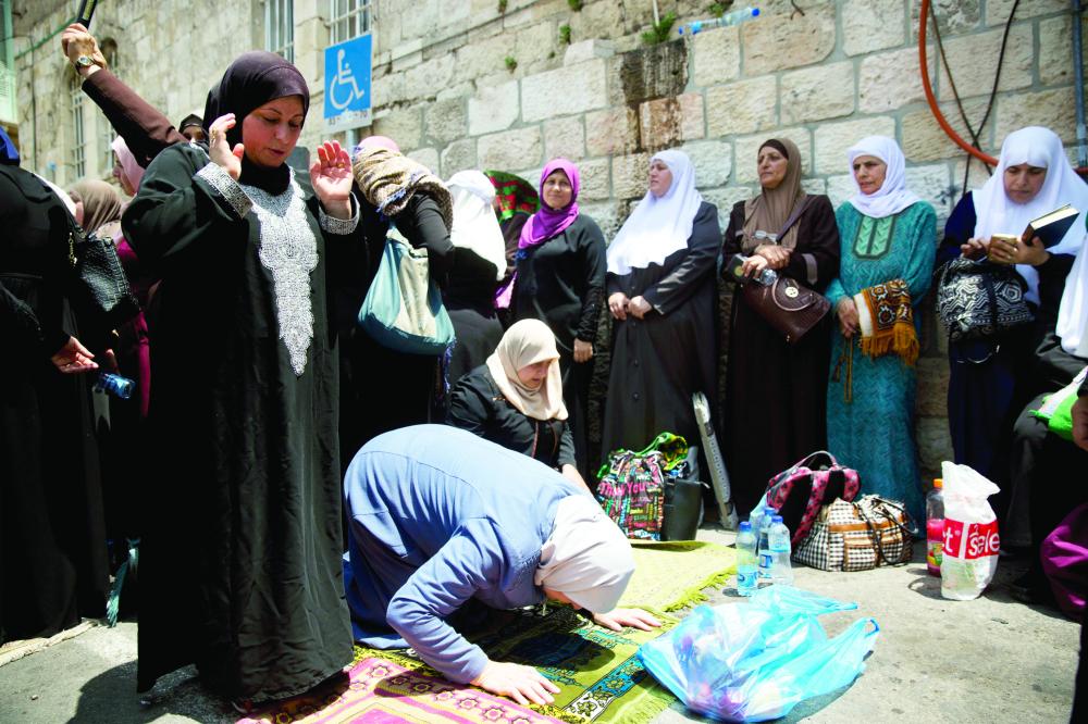 



فلسطينيات يصلين في بوابة الأسد في القدس القديمة أمس. (أ.ف.ب)