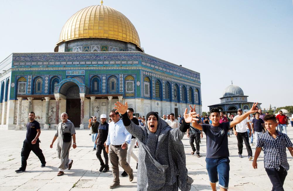 



امرأة فلسطينية تعبر عن سعادتها لحظة الدخول إلى حرم المسجد الأقصى بعد إعادة افتتاحه أمام المصلين.