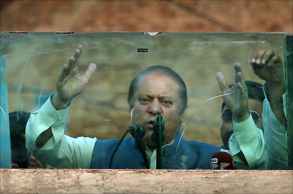 Deposed Pakistani Prime Minister Nawaz Sharif addresses his supporters behind glass during a rally in Jhelum, Pakistan, Thursday, Aug. 10, 2017. Sharif criticized the country's judiciary for disqualifying him from office for concealing assets. Nawaz Sharif's remarks came as he headed to his home city of Lahore on the second day of on-the-road rallies amid tight security. (AP Photo/ Anjum Naveed)