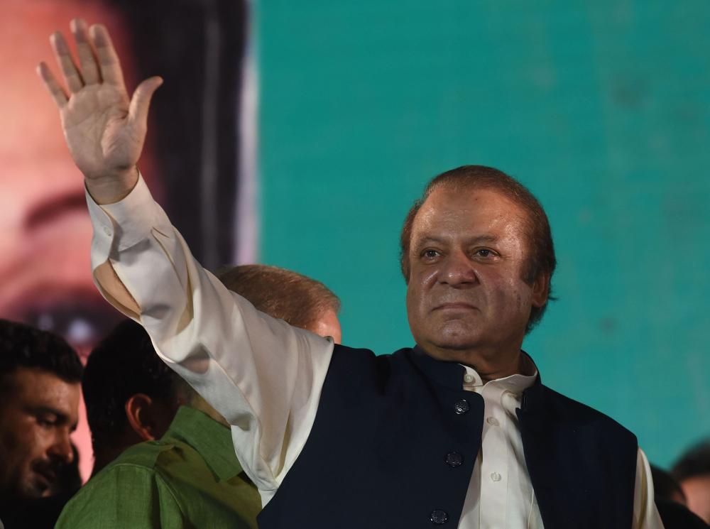 Ousted Pakistani Prime Minister Nawaz Sharif gestures as he addresses supporters at a rally after reaching his home city of Lahore on August 12, 2017.

Pakistan's former Prime Minister Nawaz Sharif's defiant procession down the ancient Grand Trunk Road after his departure from office arrived in the outskirts of his eastern stronghold of Lahore as thousands rallied support. / AFP PHOTO / ARIF ALI