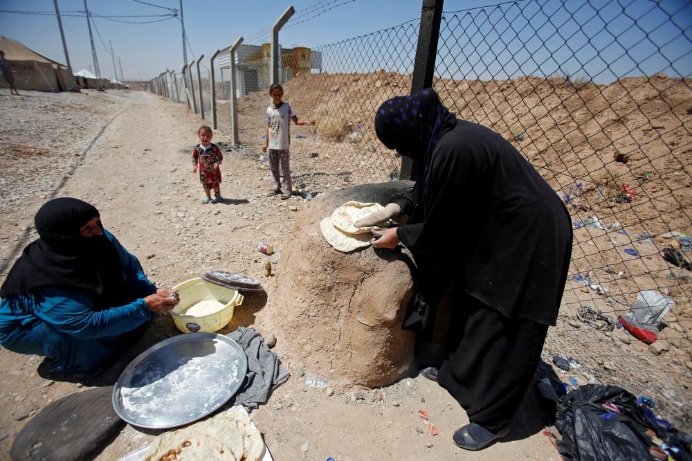 عراقيتان من تلعفر تصنعان الخبر في مخيم سلمية شرق الموصل. (رويترز)