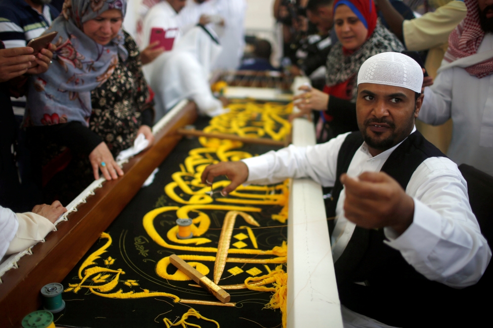 A man embroiders the Kiswa, a silk cloth covering the Holy Kaaba, ahead of the annual Haj pilgrimage, at a factory in the holy city of Makkah on Sunday. — Reuters