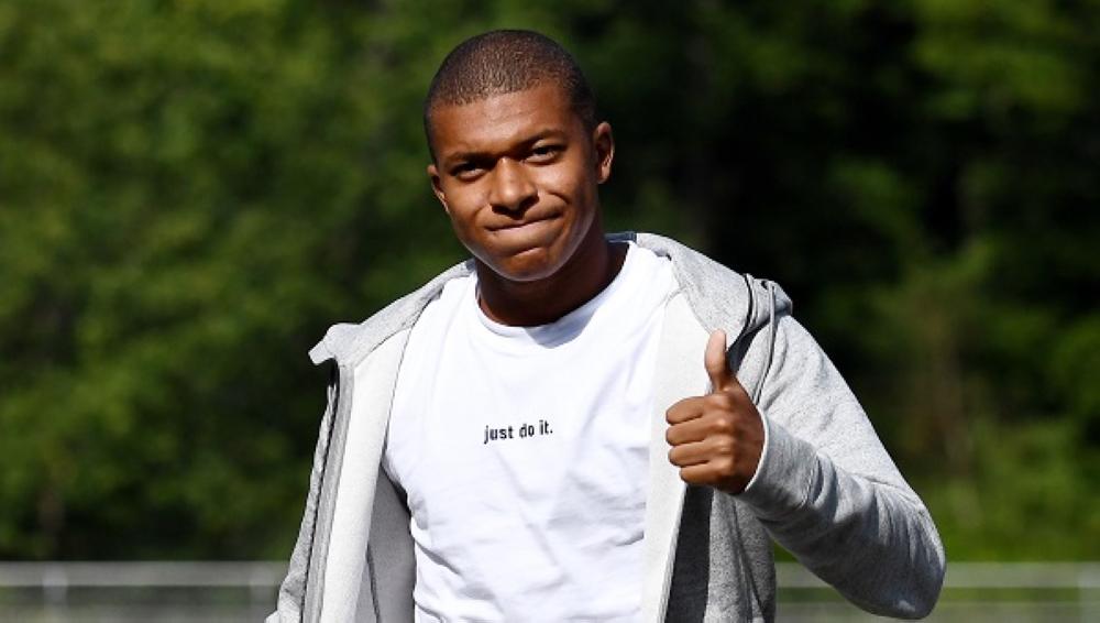 France's forward Kylian M'Bappe gives the thumbs-up as he arrives at the French national football team training base in Clairefontaine on August 28, 2017,  as part of the team's preparation for the FIFA World Cup 2018 qualifying football match against Netherlands and Luxembourg.  Monaco's teen sensation Kylian Mbappe is expected to complete a stunning move to Paris Saint-Germain when he flies into the French capital on August 28, according to widespread French media reports. Radio stations France Info and RMC revealed on Sunday that PSG had agreed to pay 180 million euros ($215 million) including bonuses for the 18-year-old French international striker. / AFP / FRANCK FIFE
