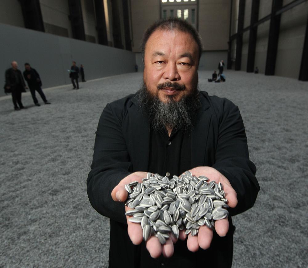 LONDON, ENGLAND - OCTOBER 11:  Chinese Artist Ai Weiwei holds some seeds from his Unilever Installation 'Sunflower Seeds'  at The Tate Modern on October 11, 2010 in London, England. The sculptural installation comprises 100 million handmade porcelain replica sunflower seeds. Visitors to the Turbine Hall  will be able to walk on the work - which opens on October 12, 2010 and runs until May 2, 2011.  (Photo by Peter Macdiarmid/Getty Images) *** Local Caption *** Ai Weiwei