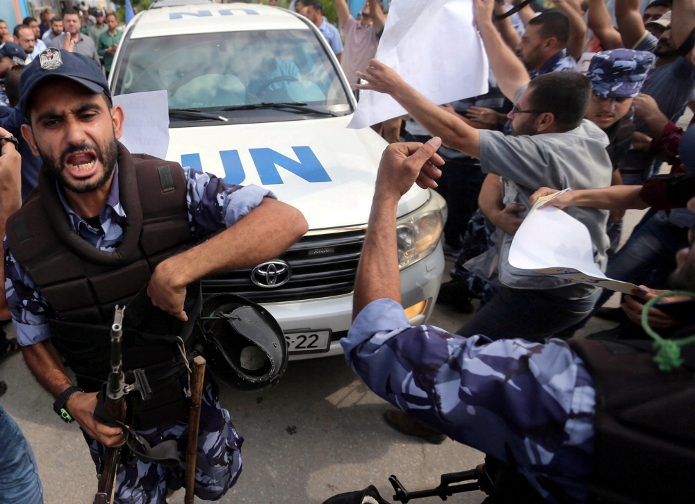 A Palestinian policeman loyal to Hamas, reacts as people try to block the convoy of United Nations Secretary-General Antonio Guterres upon his arrival near Erez crossing in the northern Gaza Strip August 30, 2017. REUTERS/Ibraheem Abu Mustafa TPX IMAGES OF THE DAY