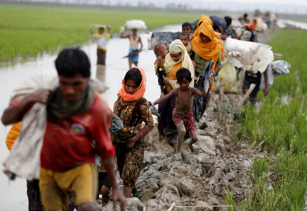 Rohingya refugees walk on the muddy path after crossing the Bangladesh-Myanmar border in Teknaf, Bangladesh, September 3, 2017. REUTERS/Mohammad Ponir Hossain TPX IMAGES OF THE DAY