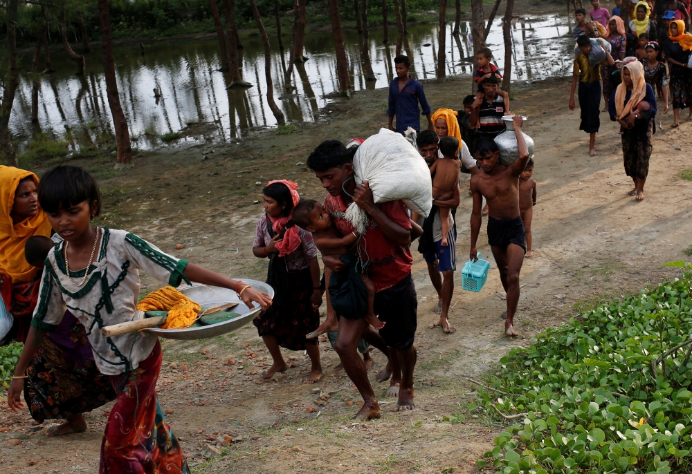 Rohingya refugees walk to the nearest village after crossing the Bangladesh-Myanmar border by boat through the Bay of Bengal in Teknaf, Bangladesh, September 5, 2017. REUTERS/Mohammad Ponir Hossain