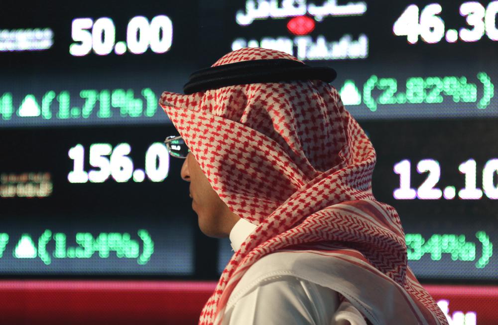 A Saudi man walks at the Tadawul Saudi Stock Exchange, in Riyadh, Saudi Arabia, Monday, June 15, 2015. Saudi Arabia's stock market, valued at $585 billion, opened up to direct foreign investment for the first time Monday, as the kingdom seeks an economic boost amid low global oil prices. (AP Photo/Hasan Jamali)