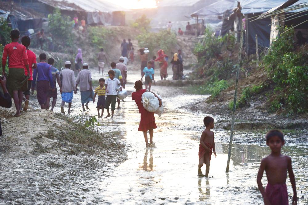 A Rohingya girl walks through a refugee camp in Kutupalong in the Bangladeshi district of Ukhia on September 8, 2017. Some 270,000 refugees have fled Myanmar's violence-wracked Rakhine state and entered Bangladesh in the last fortnight, most from the Muslim Rohingya minority, the United Nations said on September 8. / AFP / Munir UZ ZAMAN 