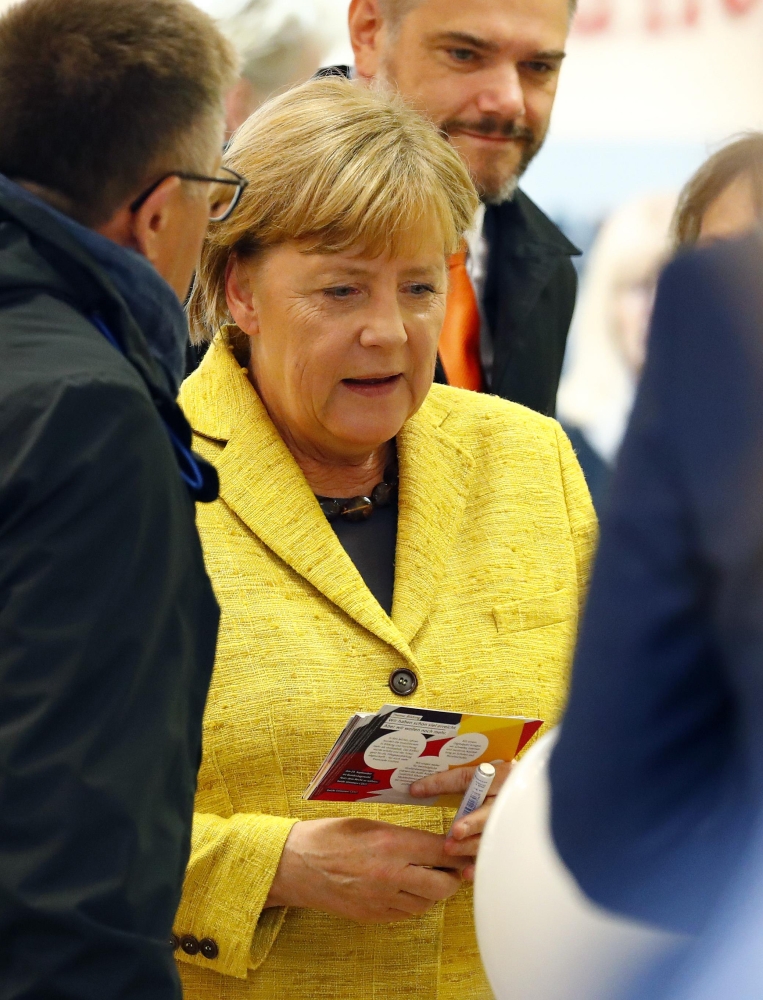 German Chancellor Angela Merkel speaks to people as she visits a shoe market during the final Christian Democratic Union (CDU) party campaign in Stralsund, Germany, September 23, 2017. REUTERS/Axel Schmidt