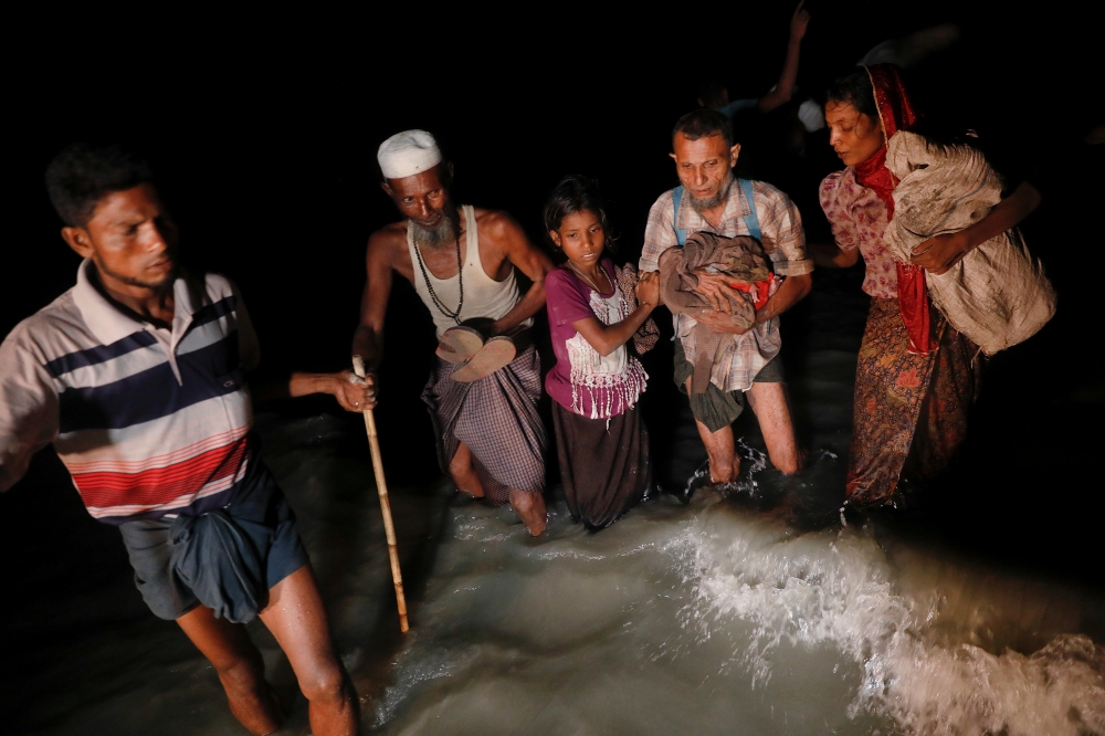 Rohingya refugees who just arrived under the cover of darkness by wooden boats from Myanmar make their way to the shore of Shah Porir Dwip, in Teknaf, near Cox's Bazar, in Bangladesh September 29, 2017. Picture taken September 29, 2017. REUTERS/Damir Sagolj