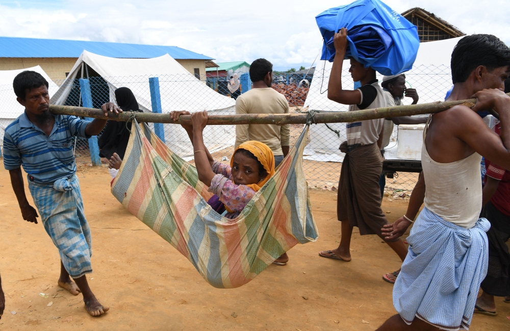 Rohingya refugees carry a sick woman at the Kutupalong refugee camp in Bangladesh's Ukhia district on October 7, 2017. Rohingya militants whose attacks triggered an army crackdown in Myanmar's Rakhine state unleashing a huge wave of refugees said October 7 their one-month ceasefire would end in two days, but added they were open to peace if the government reciprocated.
/ AFP / INDRANIL MUKHERJEE 