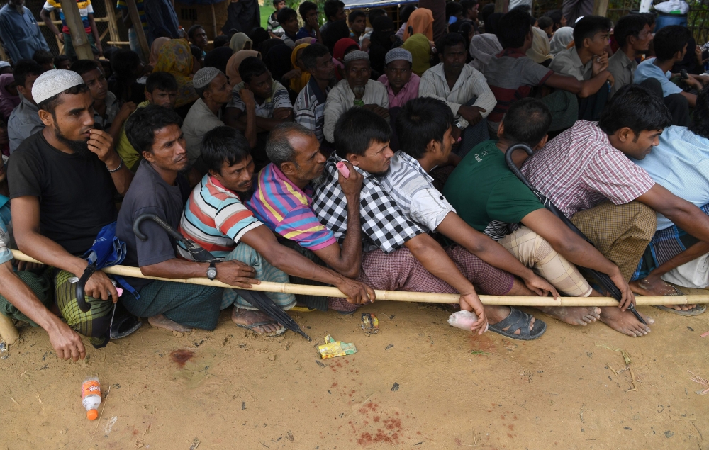 Rohingya refugees wait at a food distribution centre at the Kutupalong refugee camp in Bangladesh's Ukhia district on October 7, 2017. Rohingya militants whose attacks triggered an army crackdown in Myanmar's Rakhine state unleashing a huge wave of refugees said October 7 their one-month ceasefire would end in two days, but added they were open to peace if the government reciprocated.
/ AFP / INDRANIL MUKHERJEE 