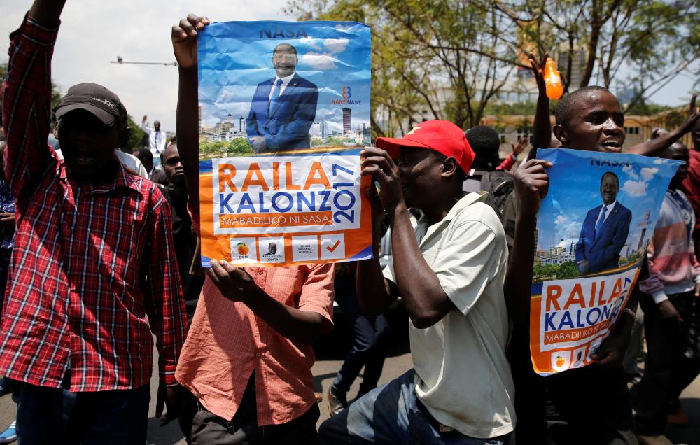 Supporters of Kenyan opposition National Super Alliance (NASA) coalition carry campaign posters of their presidential candidate Raila Odinga during a demonstration in Nairobi, Kenya October 16, 2017. REUTERS/Thomas Mukoya