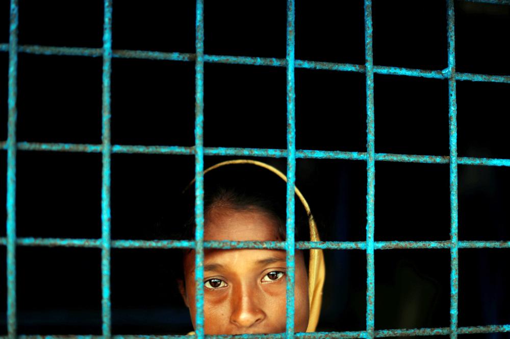 A Rohingya refugee who crossed the border from Myanmar this week stands at a window of a school used as a shelter at Kotupalang refugee camp near Cox's Bazar, Bangladesh October 20, 2017. REUTERS/Jorge Silva TPX IMAGES OF THE DAY