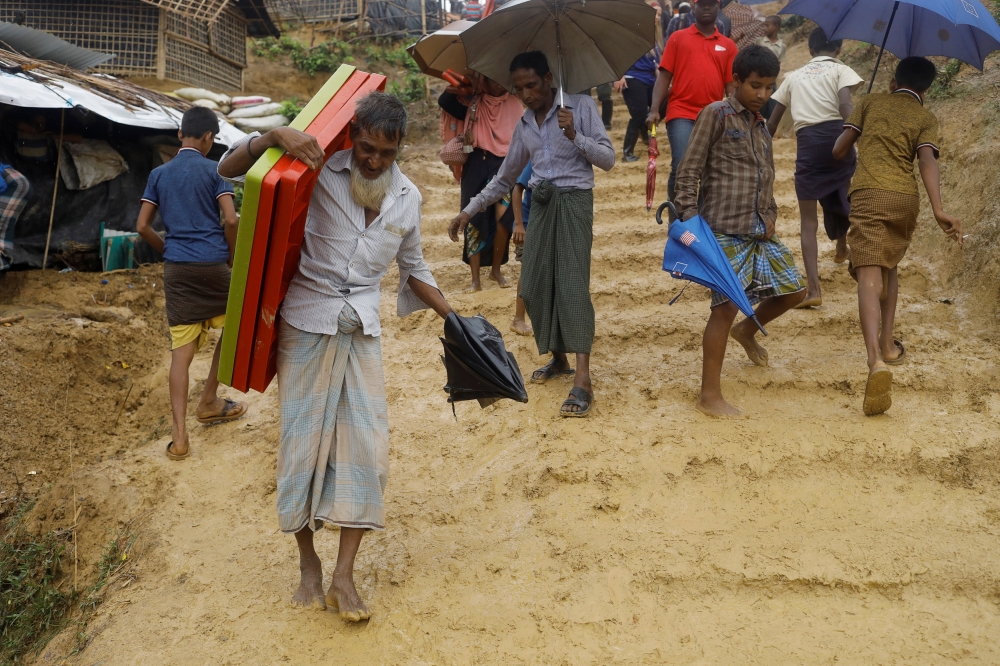 Rohingya refugees walk in mud in Kutupalong refugees camp in Cox's Bazar, Bangladesh, October 20, 2017. REUTERS/ Zohra Bensemra