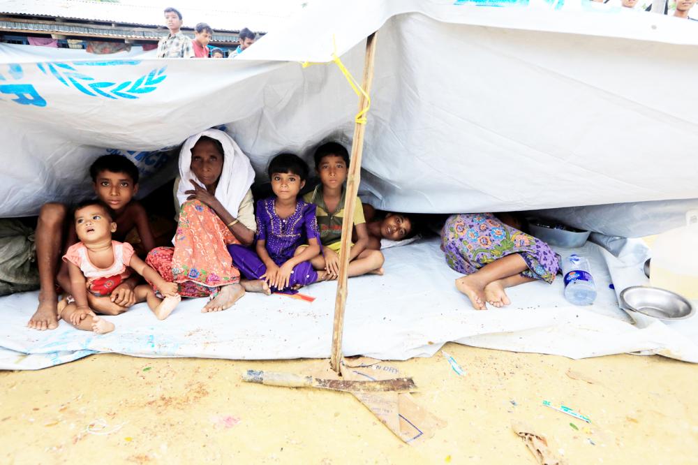 Rohingya refugees who crossed the border from Myanmar this week sit outside a school used as a shelter at Kotupalang refugee camp near Cox's Bazar, Bangladesh October 20, 2017. REUTERS/ Zohra Bensemra