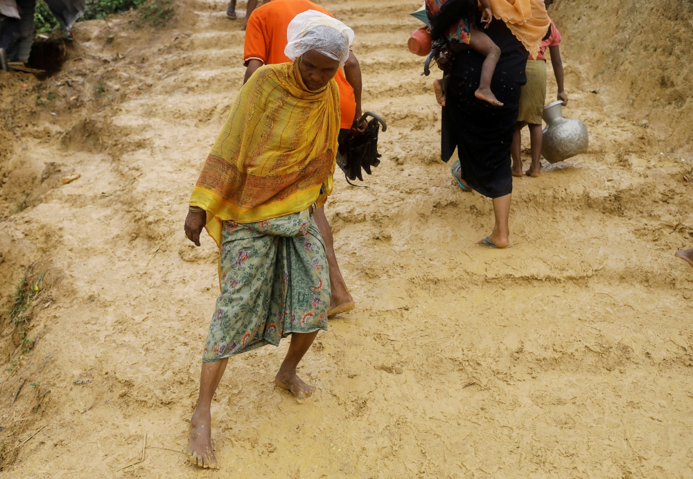 Rohingya refugees walk in mud in Kutupalong refugees camp in Cox's Bazar, Bangladesh, October 20, 2017. REUTERS/ Zohra Bensemra