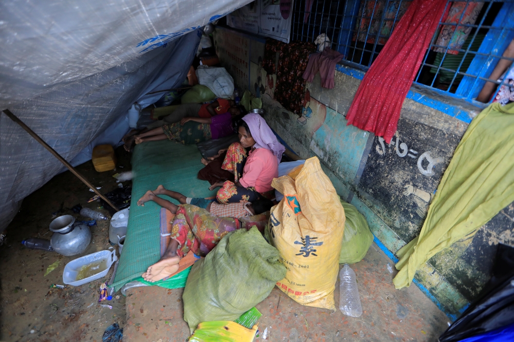 Rohingya refugees who crossed the border from Myanmar this week rest outside a school used as a shelter at Kotupalang refugee camp near Cox's Bazar, Bangladesh October 20, 2017. REUTERS/ Zohra Bensemra