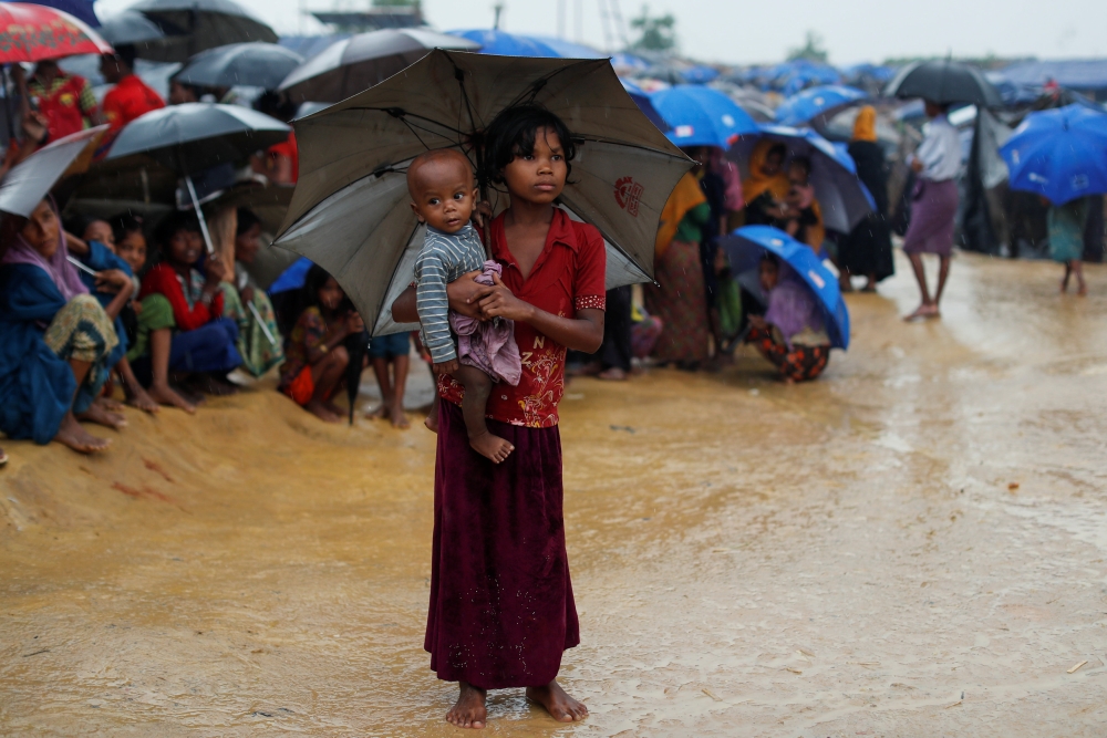 Rohingya refugees queue in the rain to receive food at Kotupalang refugee camp near Cox's Bazar, Bangladesh October 20, 2017. REUTERS/Jorge Silva