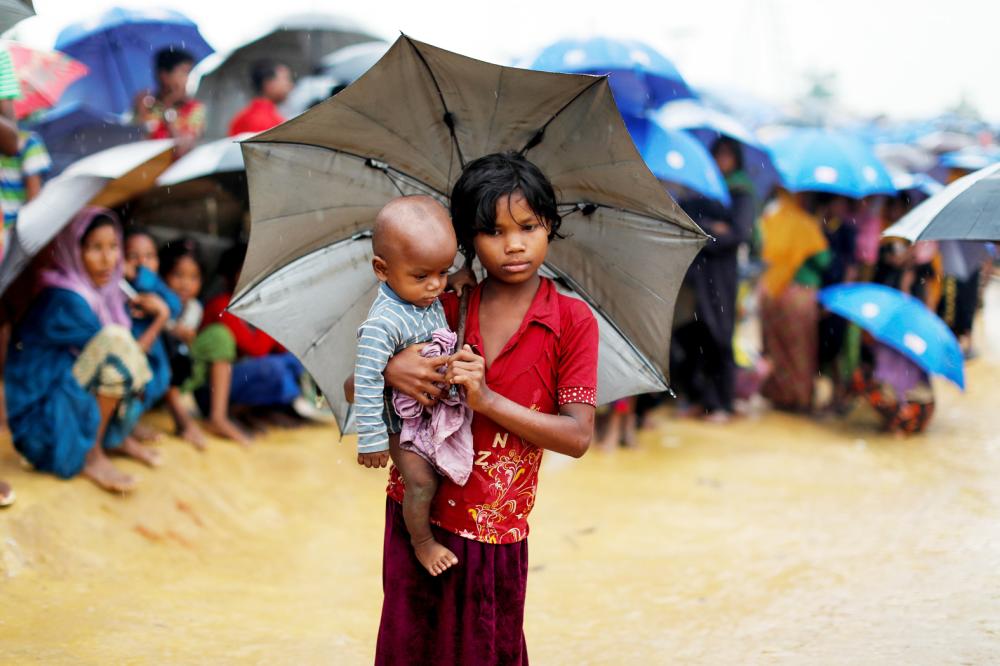 Rohingya refugees queue in the rain to receive food at Kotupalang refugee camp near Cox's Bazar, Bangladesh October 20, 2017. REUTERS/Jorge Silva