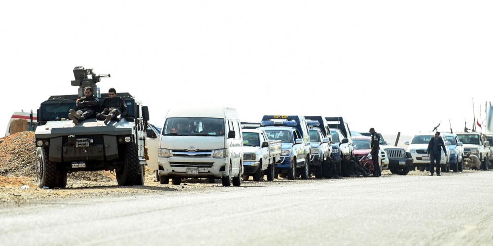 A picture taken on October 21, 2017 shows Egyptian security forces' vehicles and armoured personnel carriers (APCs) parked on the desert road towards the Bahariya oasis in Egypt's Western desert, about 135 kilometres (83 miles) southwest of Giza, near the site of an attack that left dozens of police officers killed in an ambush by Islamist fighters. An official statement said a number of the attackers were killed, but did not give any figures for losses on either side.
Medics and security sources gave a death toll of 35 among police. / AFP / MOHAMED EL-SHAHED
