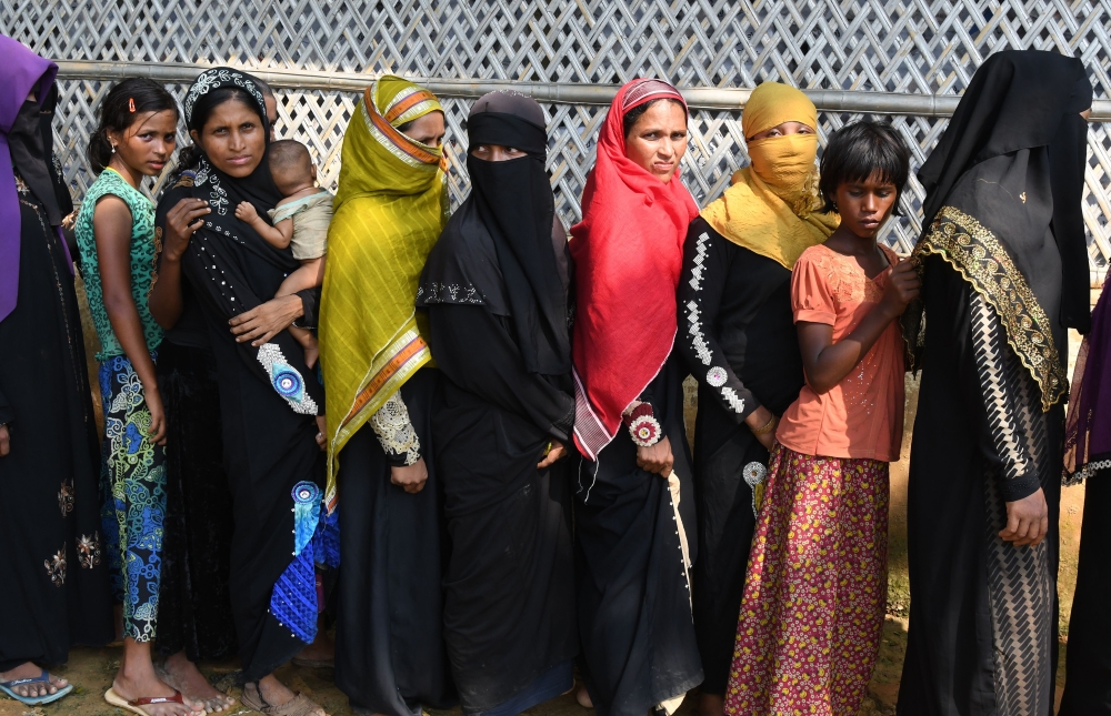 Rohingya Muslim refugees wait for relief aid at Kutupalong refugee camp in the Bangladeshi district of Ukhia on October 25, 2017. Myanmar and Bangladesh have agreed to work together to repatriate hundreds of thousands of Rohingya Muslim refugees, officials said, but details remain thin as the humanitarian crisis deepens. Ties between the neighbours have been severely strained by army-led violence in Myanmar's Rakhine state that has driven more than 600,000 Rohingya into Bangladesh since late August. / AFP / TAUSEEF MUSTAFA
