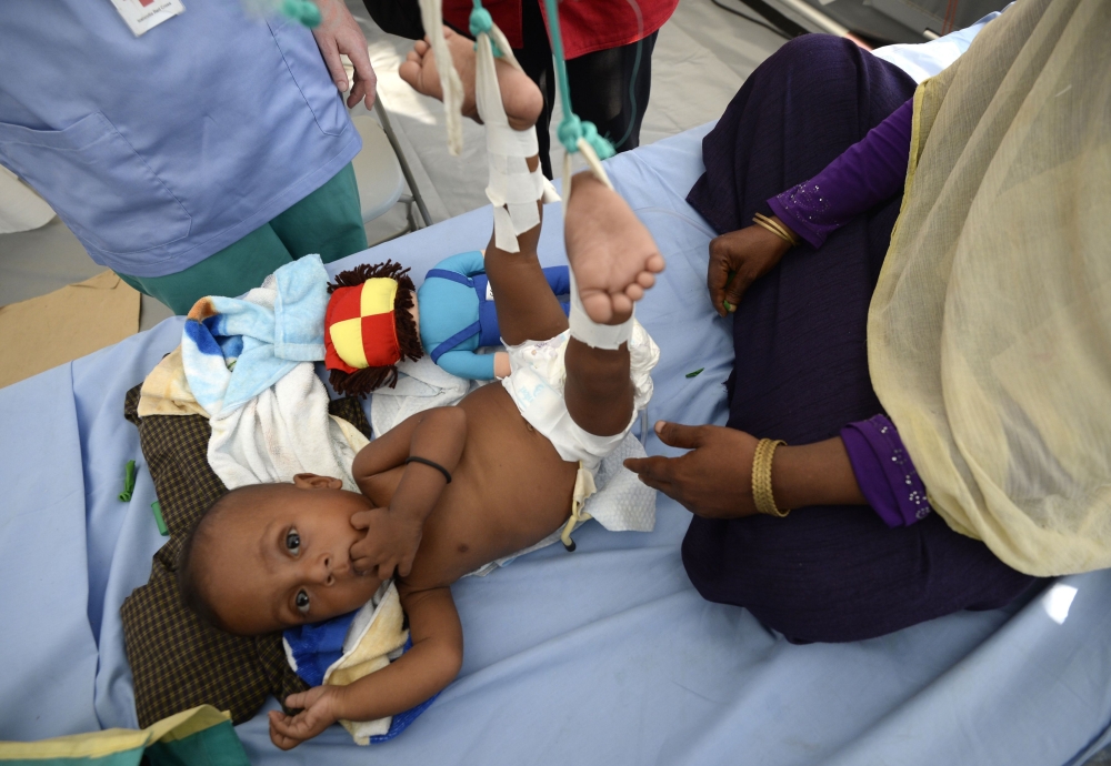 Rohingya Muslim refugee Shakira Bejum sits with her grandchild Shaid-Ullah at a Red Cross clinic near Kutupalong refugee camp in the Bangladeshi district of Ukhia on October 25, 2017. Myanmar and Bangladesh have agreed to work together to repatriate hundreds of thousands of Rohingya Muslim refugees, officials said, but details remain thin as the humanitarian crisis deepens. Ties between the neighbours have been severely strained by army-led violence in Myanmar's Rakhine state that has driven more than 600,000 Rohingya into Bangladesh since late August. / AFP / TAUSEEF MUSTAFA
