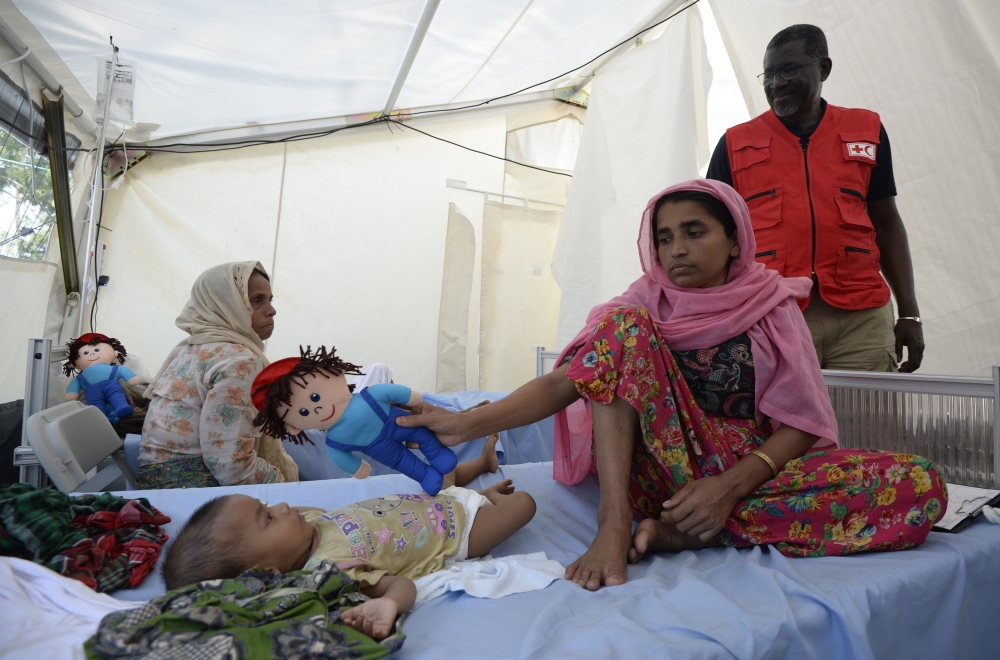 Secretary General of the International Federation of Red Cross and Red Crescent Societies (IFRC) Elhadj As Syat (C) visits a Red Cross clinic treating Rohingya Muslim refugees near Kutupalong refugee camp in the Bangladeshi district of Ukhia on October 25, 2017. Myanmar and Bangladesh have agreed to work together to repatriate hundreds of thousands of Rohingya Muslim refugees, officials said, but details remain thin as the humanitarian crisis deepens. Ties between the neighbours have been severely strained by army-led violence in Myanmar's Rakhine state that has driven more than 600,000 Rohingya into Bangladesh since late August. / AFP / TAUSEEF MUSTAFA
