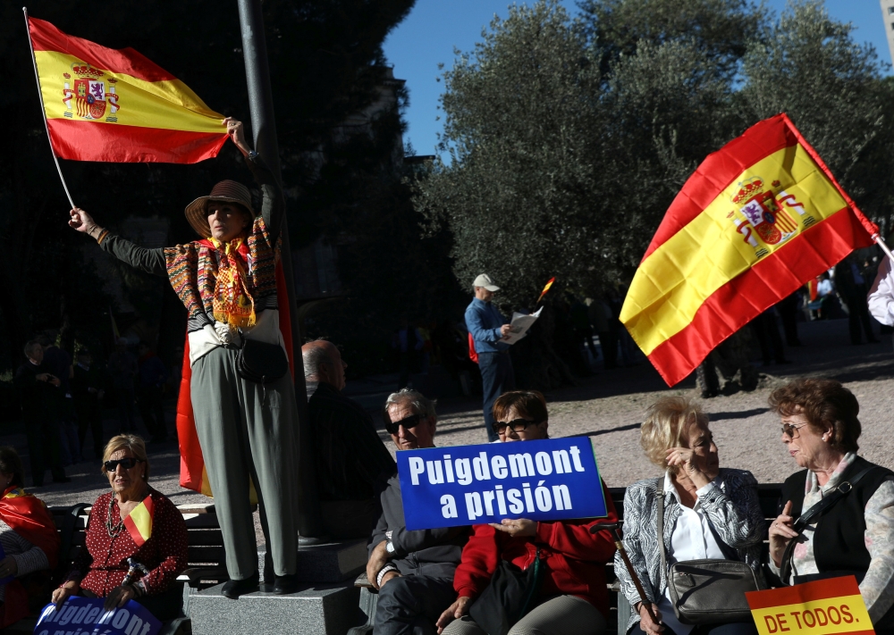 Pro-unity demonstrators with a sign calling for the imprisonment of sacked Catalan President Carles Puigdemont, gather in Madrid, Spain, October 28, 2017. REUTERS/Susana Vera