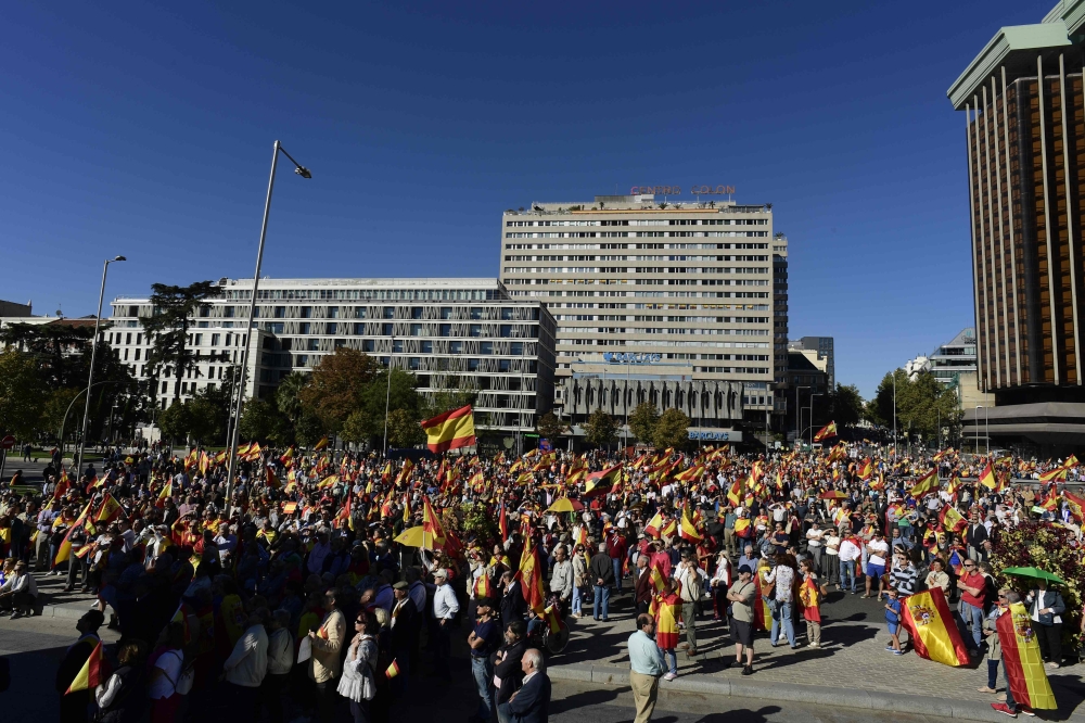 People wave Spanish flags during a demonstration calling for unity at Plaza de Colon in Madrid on October 28, 2017, a day after direct control was imposed on Catalonia over a bid to break away from Spain. Spain moved to assert direct rule over Catalonia, replacing its executive and top functionaries to quash an independence drive that has plunged the country into crisis and unnerved secession-wary Europe. / AFP / JAVIER SORIANO
