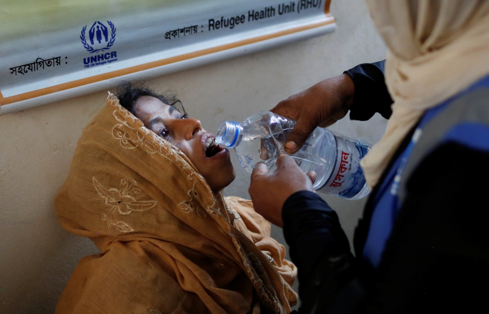 Salima Khatun, 30, a Rohingya refugee who is eight months pregnant, drinks water before seeing a doctor at a medical centre in Kutupalong refugee camp near Cox's Bazar, Bangladesh October 28, 2017. REUTERS/Adnan Abidi