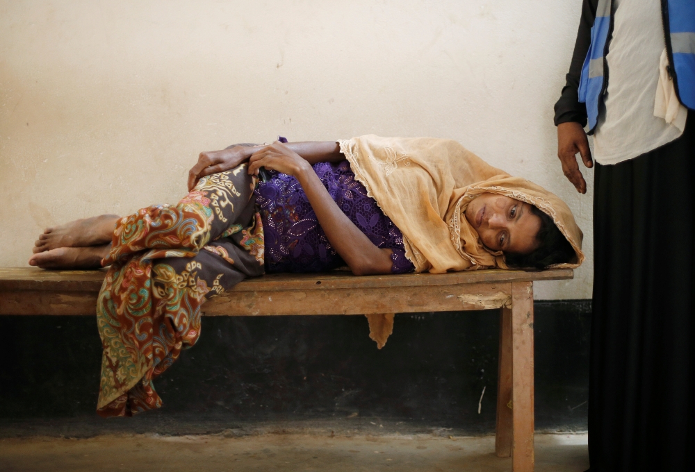 Salima Khatun, 30, a Rohingya refugee who is eight months pregnant, lies on a bench as she waits to see a doctor at a medical centre in Kutupalong refugee camp near Cox's Bazar, Bangladesh October 28, 2017. REUTERS/Adnan Abidi