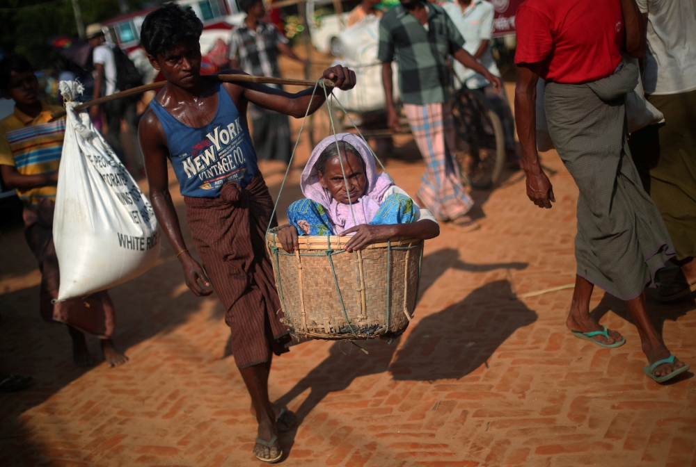 Amina, 70, a Rohingya refugee is carried by her son through Kutupalong refugee camp near Cox's Bazar, Bangladesh, October 26, 2017. REUTERS/Hannah McKay     TPX IMAGES OF THE DAY