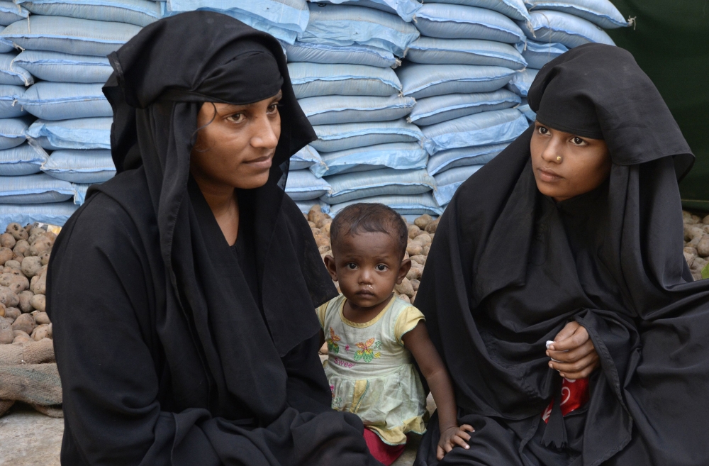In this photograph taken on October 24, 2017, Rohingya Muslim refugees wait outside a government-run family planning centre in the Bangladeshi town of Palongkhali. Bangladesh is planning to introduce voluntary sterilisation in its overcrowded Rohingya camps, where nearly a million refugees are fighting for space, after efforts to encourage birth control failed.
 / AFP / Tauseef MUSTAFA
