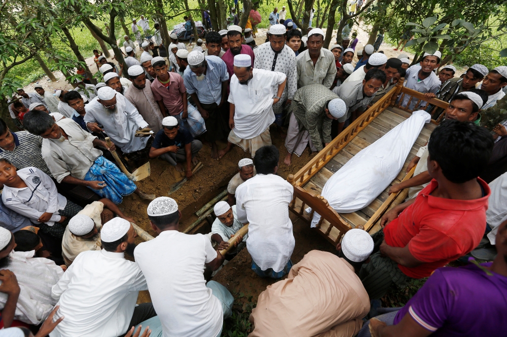 Rohingya refugees keep the body of Pawar Petan, 84, who died of an illness, near the grave before the burial at Balukhali refugee camp near Cox's Bazar, Bangladesh October 29, 2017. REUTERS/Adnan Abidi