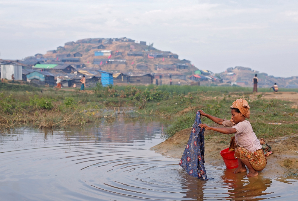 A Rohingya refugee woman washes clothes in a stream at Palong Khali refugee camp near Cox's Bazar, Bangladesh October 29, 2017. REUTERS/Adnan Abidi