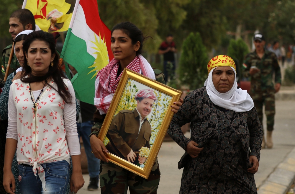 An Iraqi Kurd holds a frame portraying the Iraqi Kurdish leader Massud Barzani, during a protest in support of him, in Arbil, the capital of autonomous Iraqi Kurdistan, on October 30, 2017. Long-time Kurdish leader Massud Barzani, the architect of the referendum, announced on October 29, 2017 he is stepping down after it led to Iraq's recapture of almost all disputed territories that had been under Kurdish control. / AFP / SAFIN HAMED 