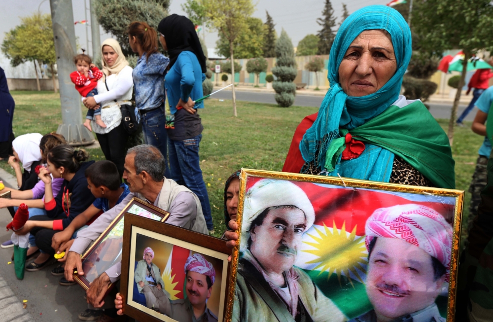 Iraqi Kurds hold frames portraying the Iraqi Kurdish leader Massud Barzani, during a protest in his support, in Arbil, the capital of autonomous Iraqi Kurdistan, on October 30, 2017. Long-time Kurdish leader Massud Barzani, the architect of the referendum, announced on October 29, 2017 he is stepping down after it led to Iraq's recapture of almost all disputed territories that had been under Kurdish control. / AFP / SAFIN HAMED 