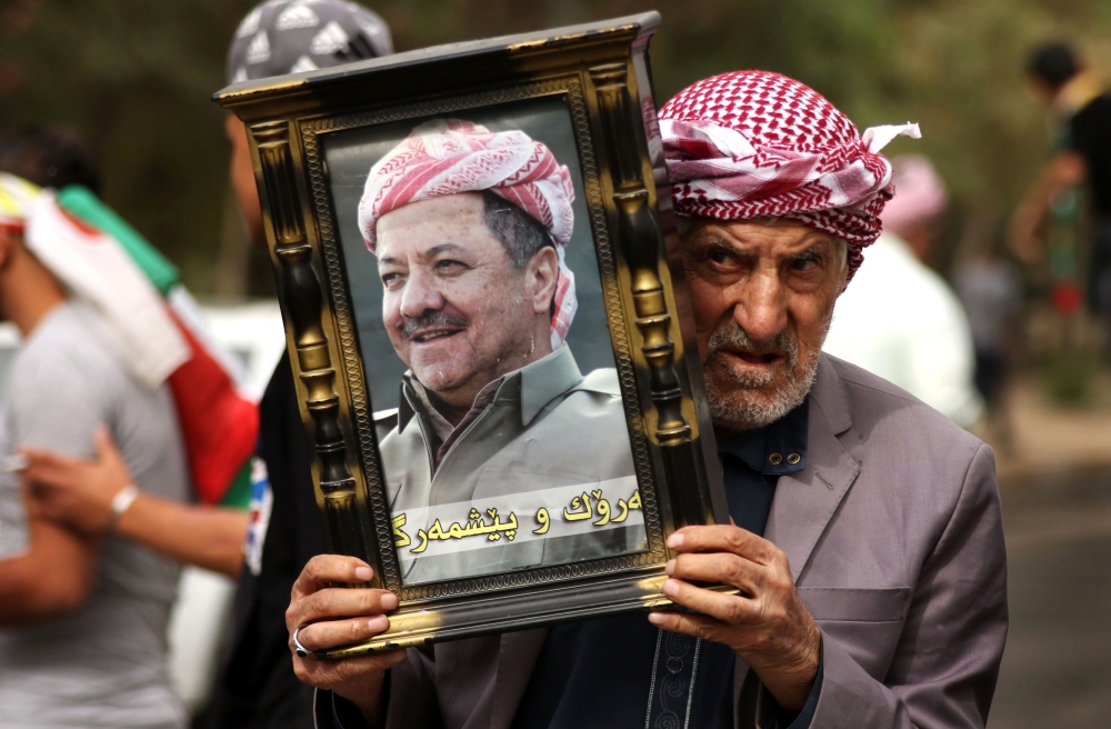 An Iraqi Kurd holds a frame portraying the Iraqi Kurdish leader Massud Barzani, during a protest in support of him, in Arbil, the capital of autonomous Iraqi Kurdistan, on October 30, 2017. Long-time Kurdish leader Massud Barzani, the architect of the referendum, announced on October 29, 2017 he is stepping down after it led to Iraq's recapture of almost all disputed territories that had been under Kurdish control. / AFP / SAFIN HAMED 