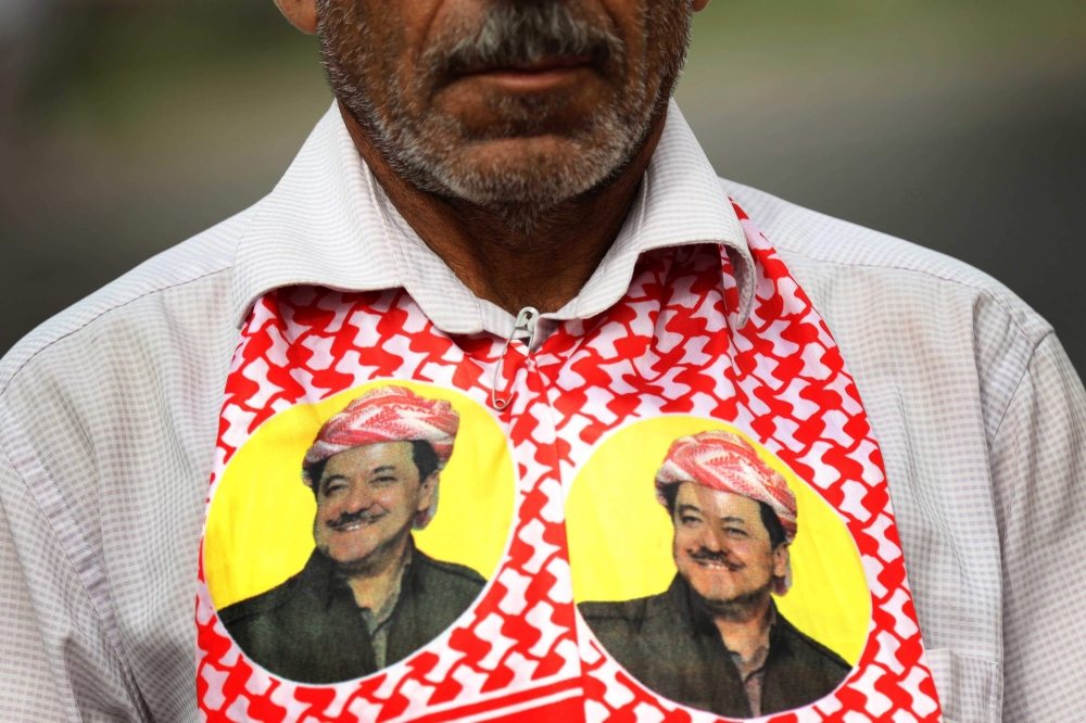 An Iraqi Kurd wears a scarf bearing a portrait of the Iraqi Kurdish leader Massud Barzani, during a protest in support of him, in Arbil, the capital of autonomous Iraqi Kurdistan, on October 30, 2017. Long-time Kurdish leader Massud Barzani, the architect of the referendum, announced on October 29, 2017 he is stepping down after it led to Iraq's recapture of almost all disputed territories that had been under Kurdish control. / AFP / SAFIN HAMED 