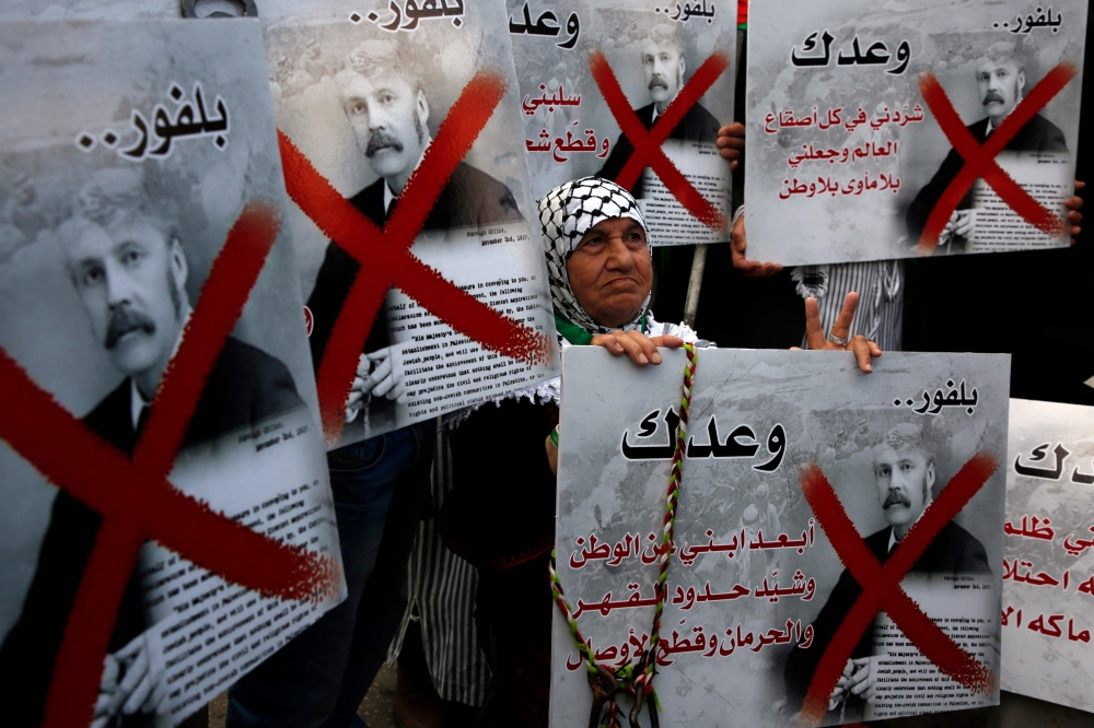 A Palestinian demonstrator carries a placard bearing the portrait of former British Prime Minister Arthur Balfour during a demonstration in northern West Bank city of Nablus on November 2, 2017, on the 100th anniversary of Britain's Balfour Declaration, which helped lead to Israel's creation and the Israeli-Palestinian conflict. / AFP / JAAFAR ASHTIYEH 