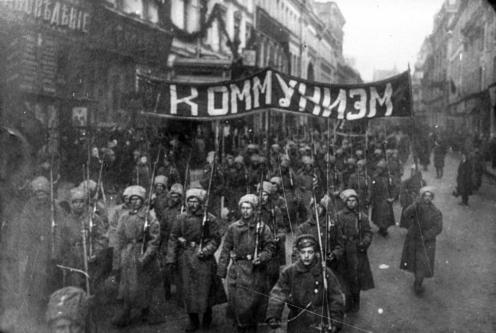 In this photo taken in Oct. 1917, provided by Russian State Documentary Film and Photo Archive, Russian State Documentary Film and Photo Archive, armed soldiers carry a banner reading 'Communism' march alone Nikolskaya street towards to the Kremlin Wall in Moscow, Russia. The 1917 Bolshevik Revolution was long before the digital revolution allowed anyone to instantly document events. But the clumsy cameras of the time still caught some images that capture the period's drama. (Russian State Documentary Film and Photo Archive via AP)