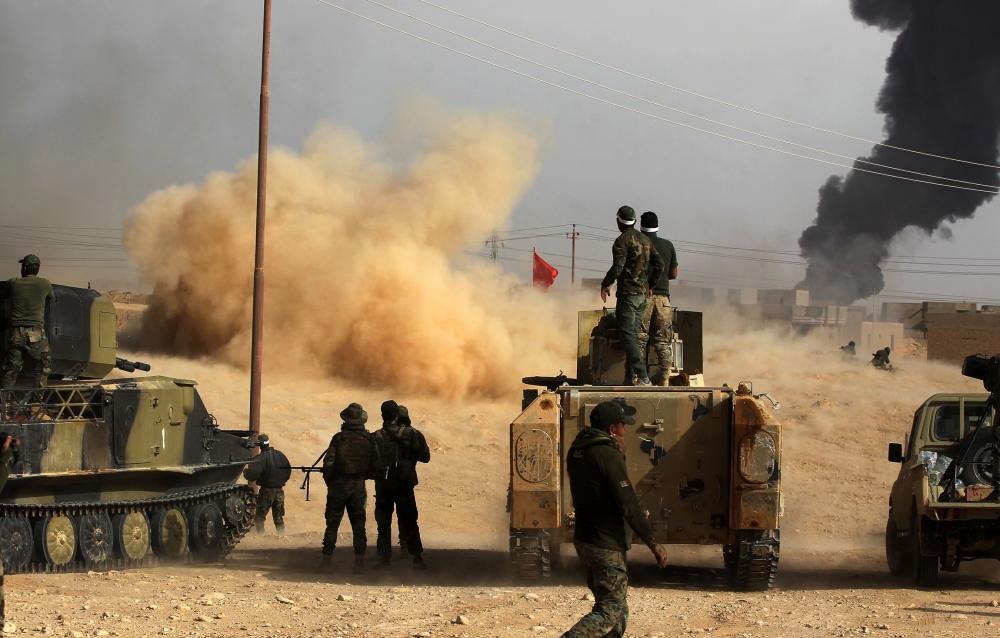 Iraqi forces and members of the Hashed al-Shaabi (Popular Mobilisation units) advance towards the city of al-Qaim, in Iraq's western Anbar province near the Syrian border as they fight against remnant pockets of Islamic State group jihadists on November 3, 2017.  / AFP / AHMAD AL-RUBAYE
